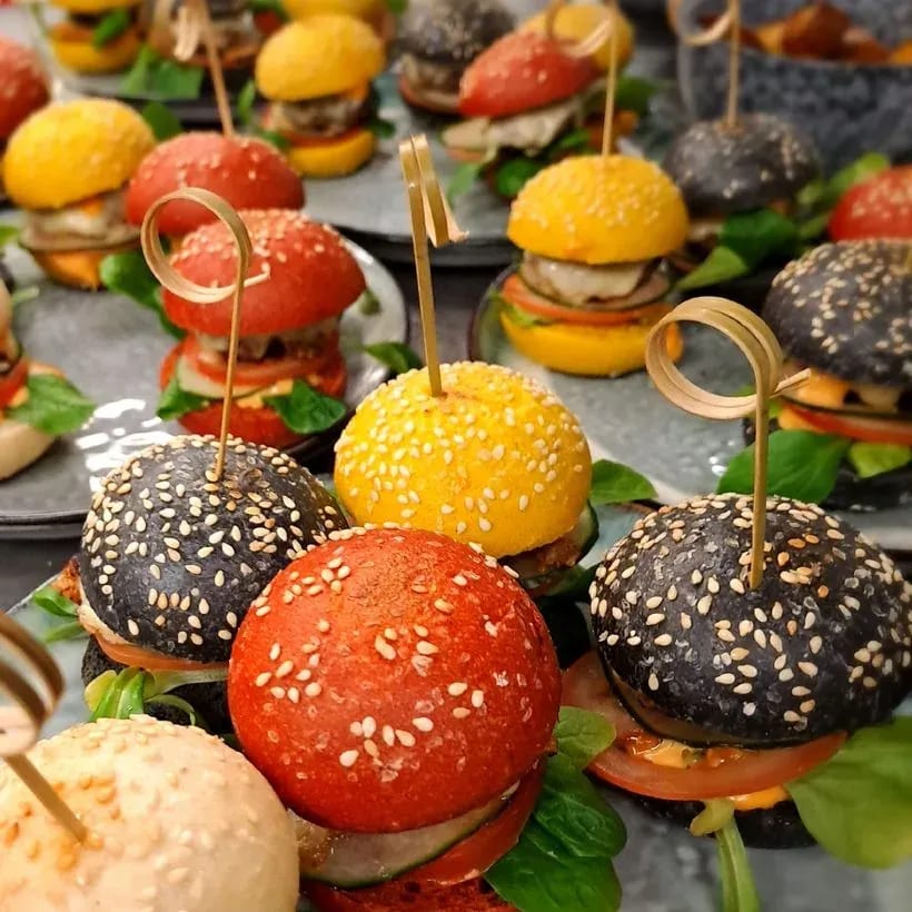 Mini-Burger in verschiedenen Brotfarben auf Platten angerichtet