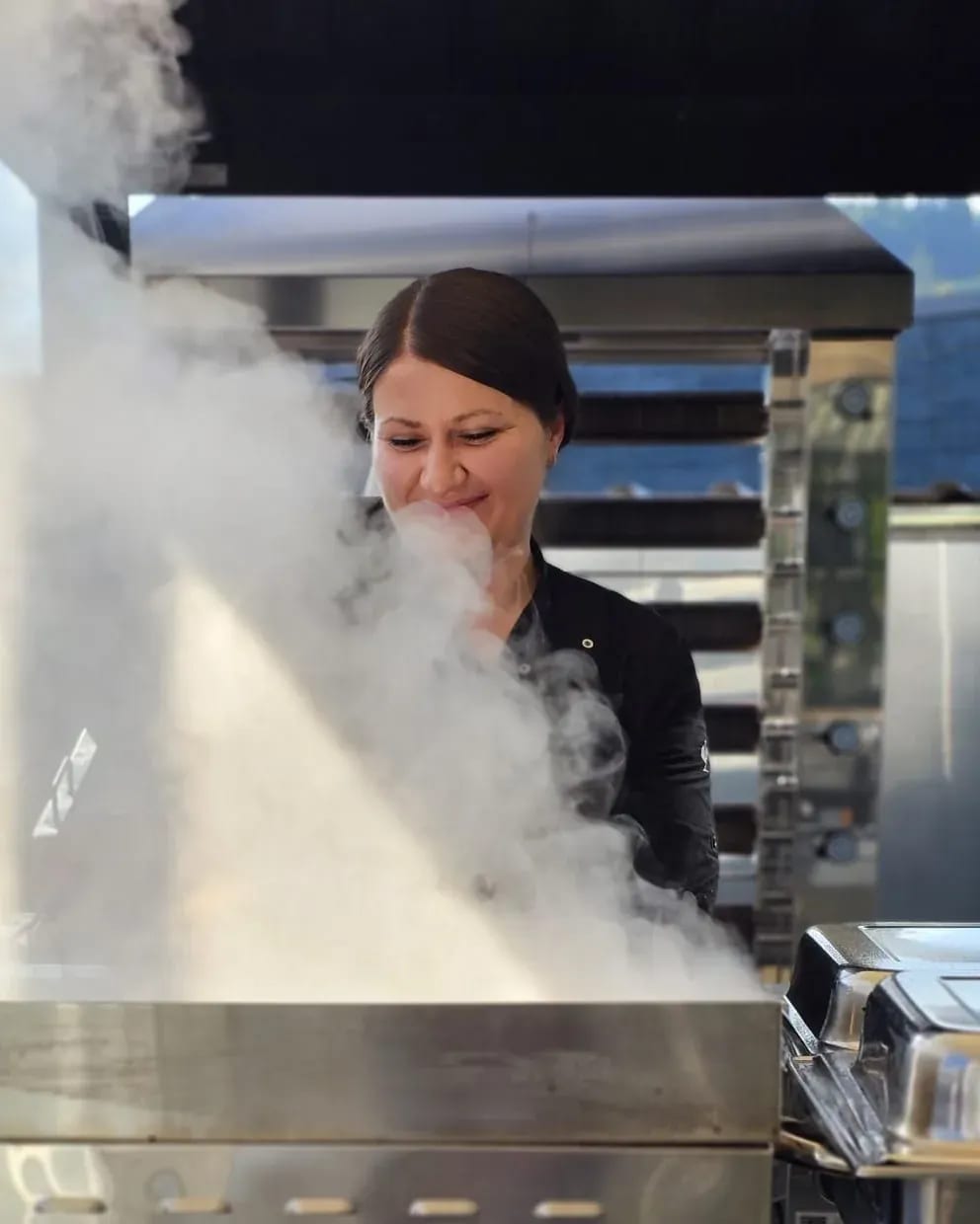 Andrea Mathes lacht hinter der dampfenden Warmhaltestation